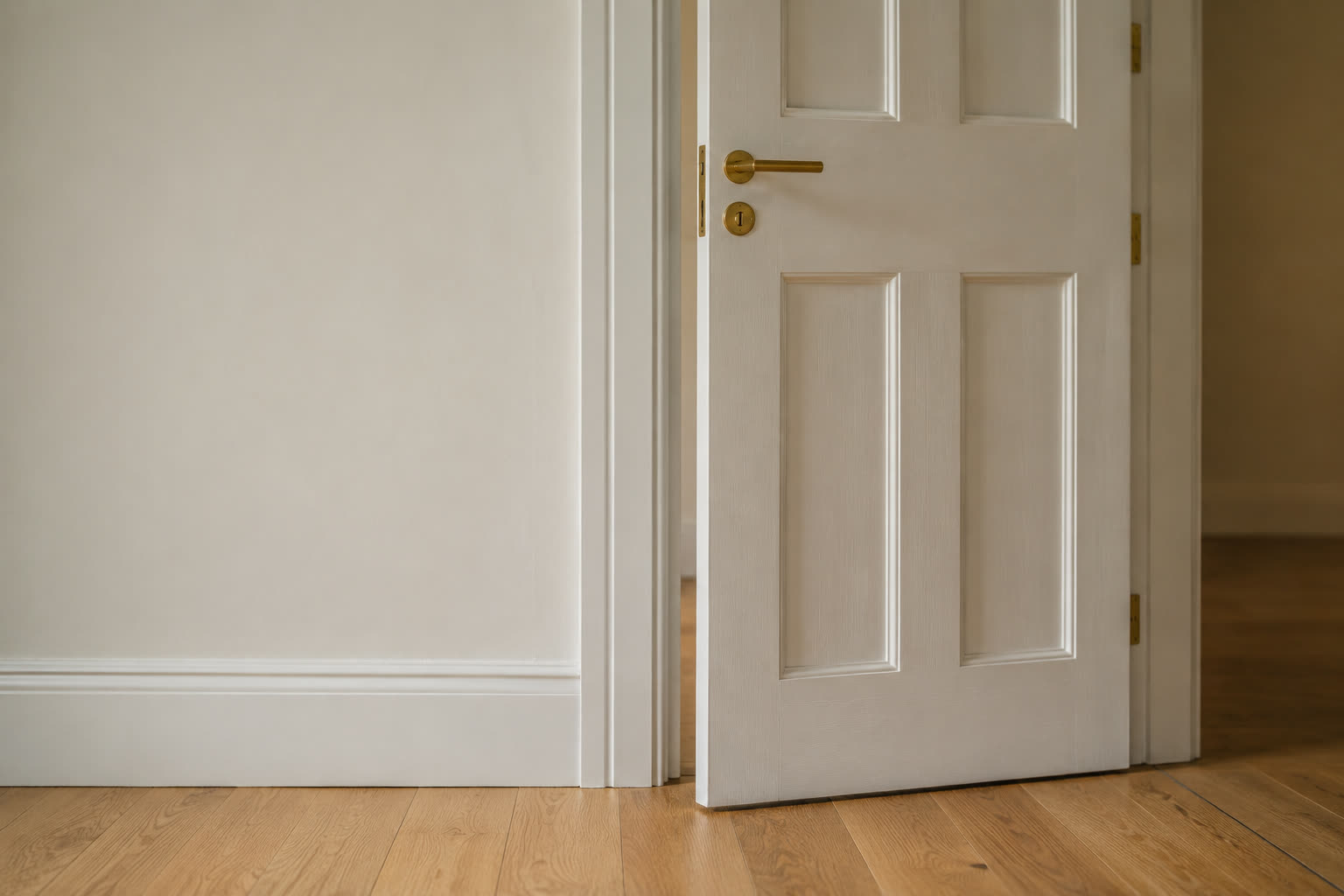 Newly hung panel door with tight architrave mitres and skirting scribed to the wall