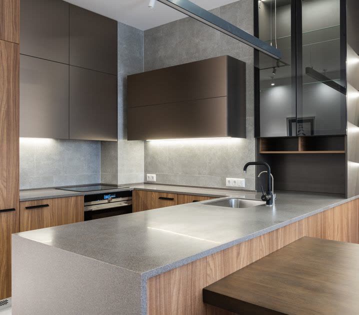 Fitted kitchen with walnut units, grey stone worktops and under-cabinet lighting