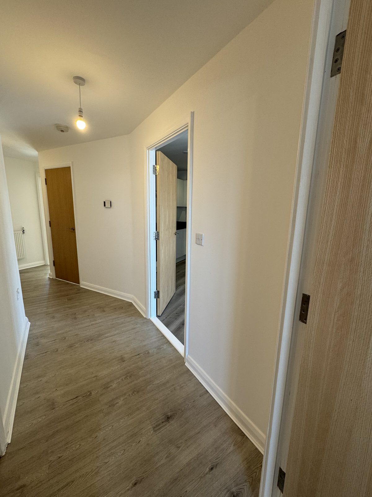 Landing with oak-veneer eaves doors and new wood-effect flooring