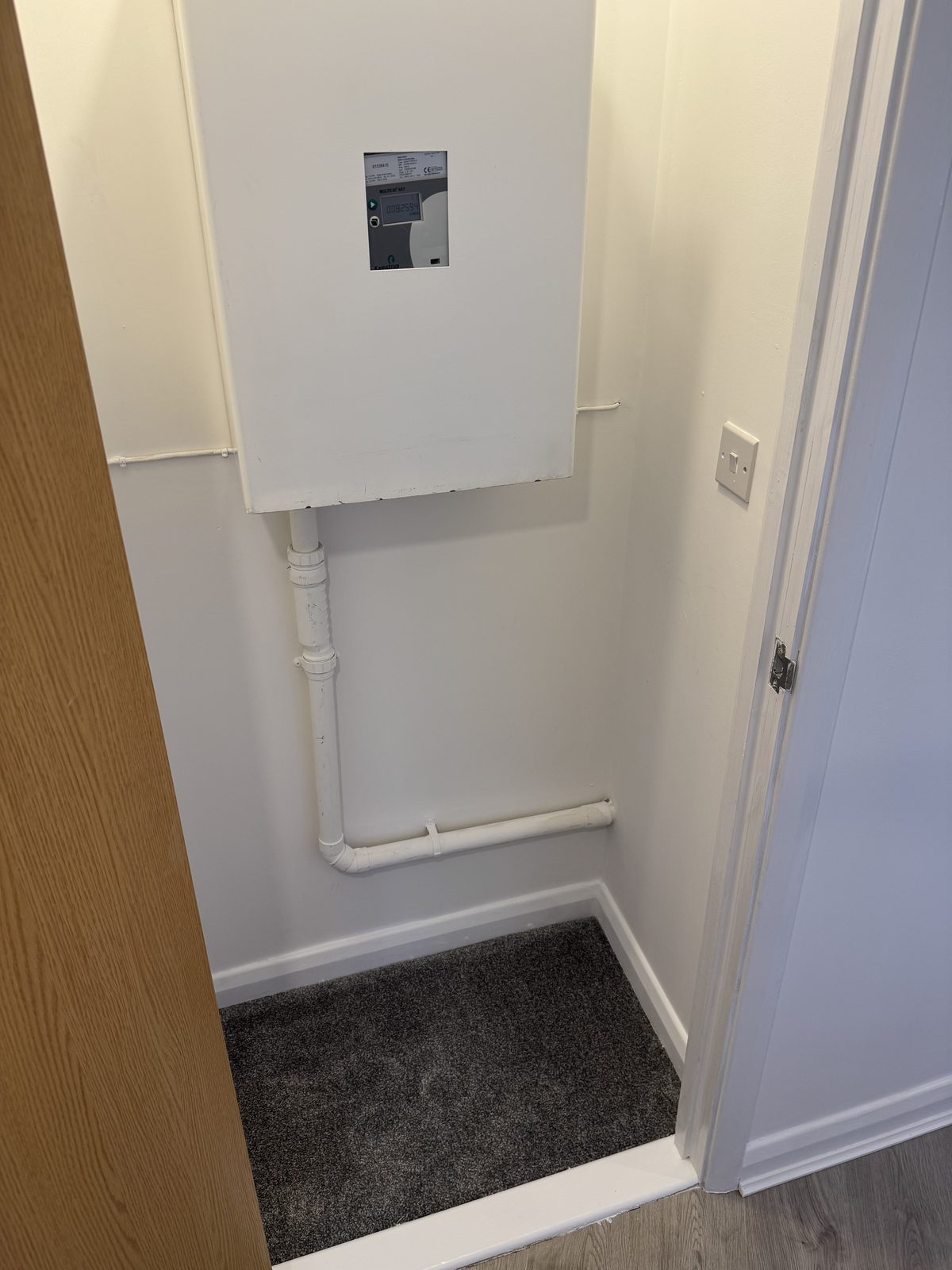 Boxed-in services and new pipework inside a fitted cupboard