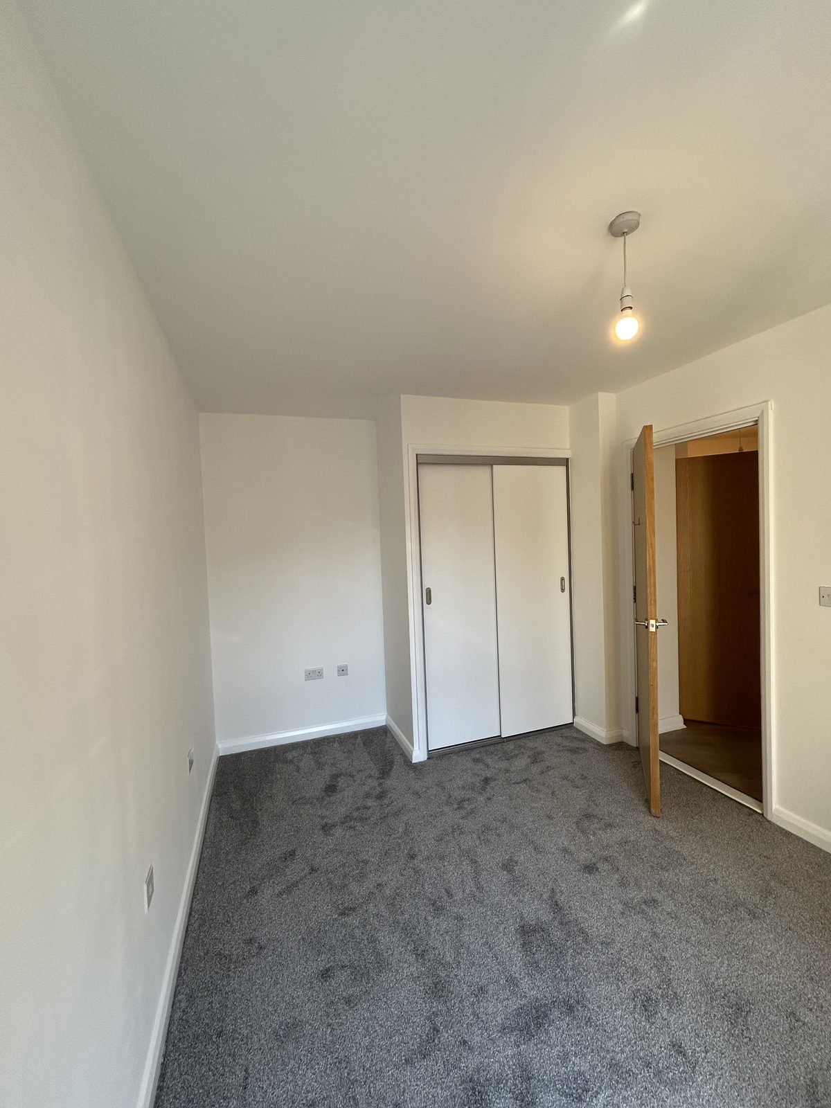 Bedroom with a sliding-door fitted wardrobe and a new oak-veneer door