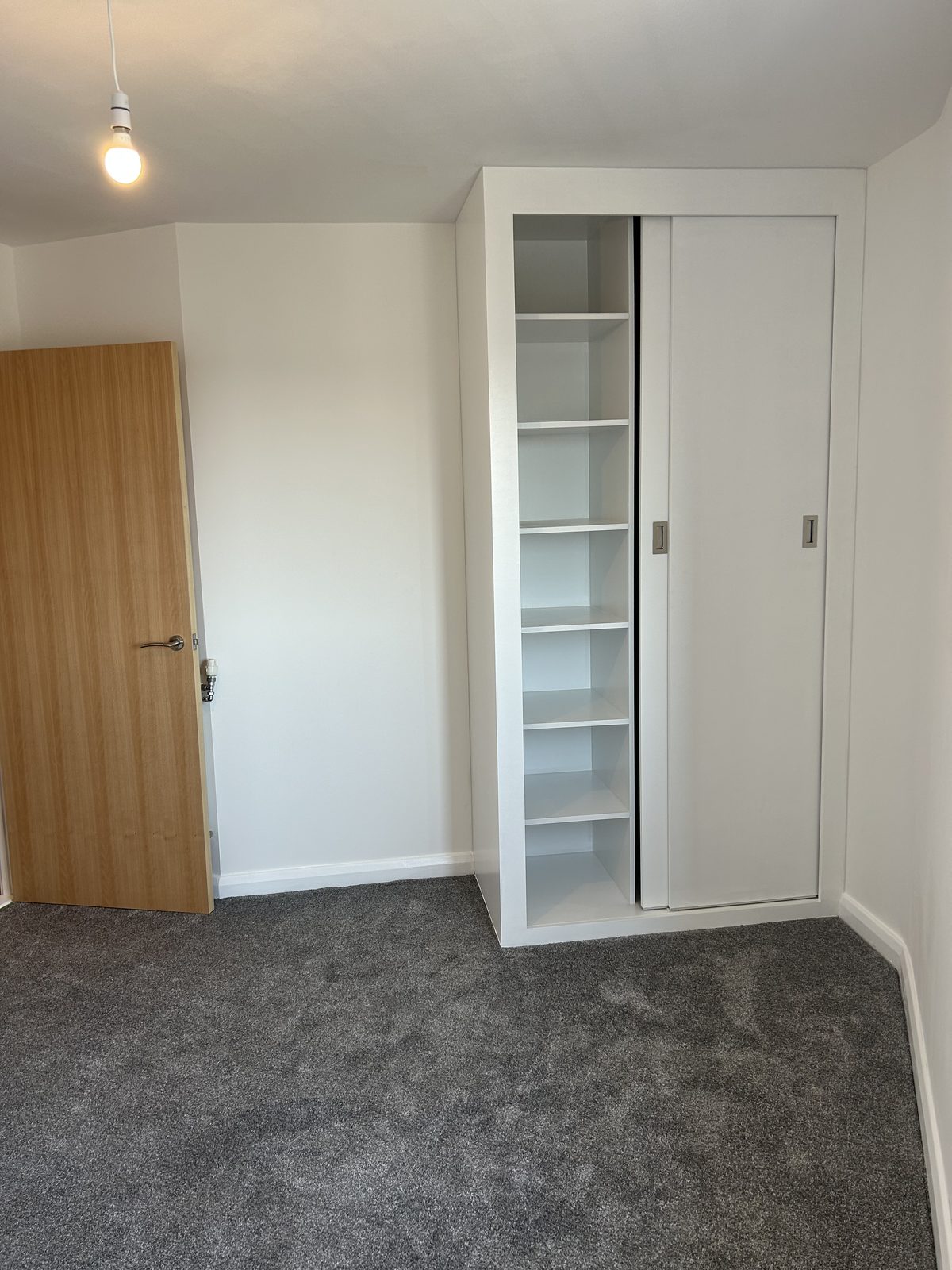 Fitted overhead cupboard with a run of open cubby shelving