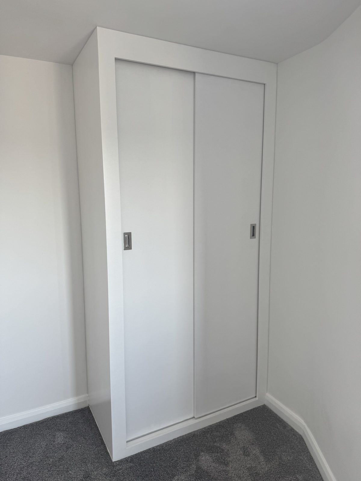 Fitted overhead cupboard closed, built into the slope of the ceiling