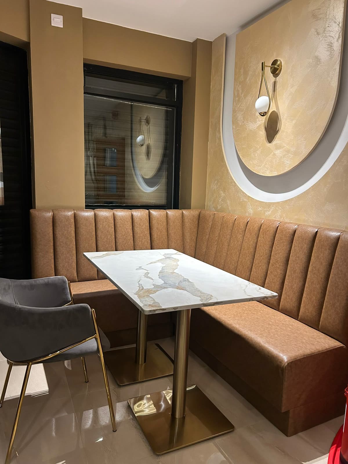 Booth seating in fluted leather beneath an arched wall recess