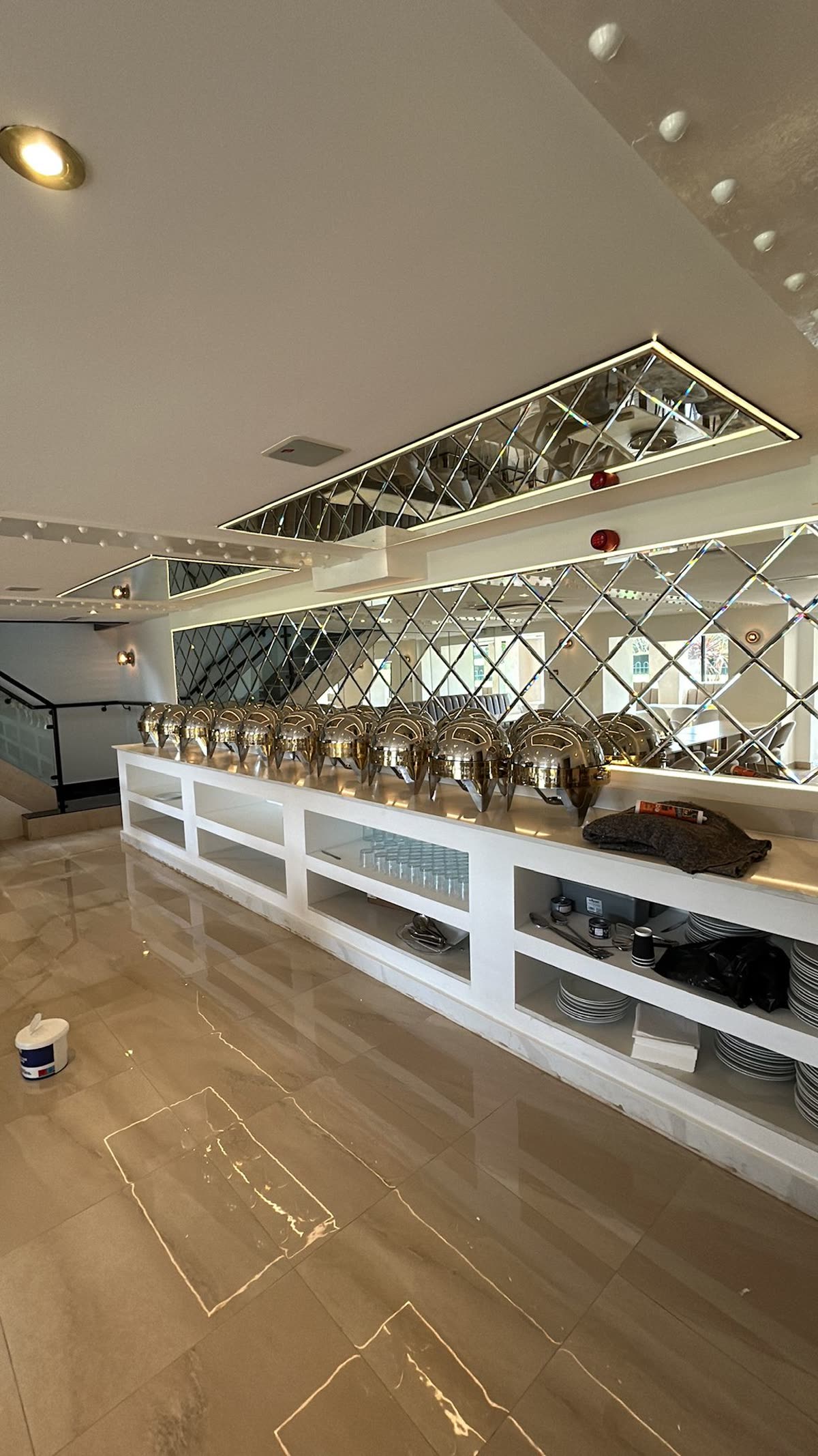 Servery counter with a mirrored diamond splashback and open shelving