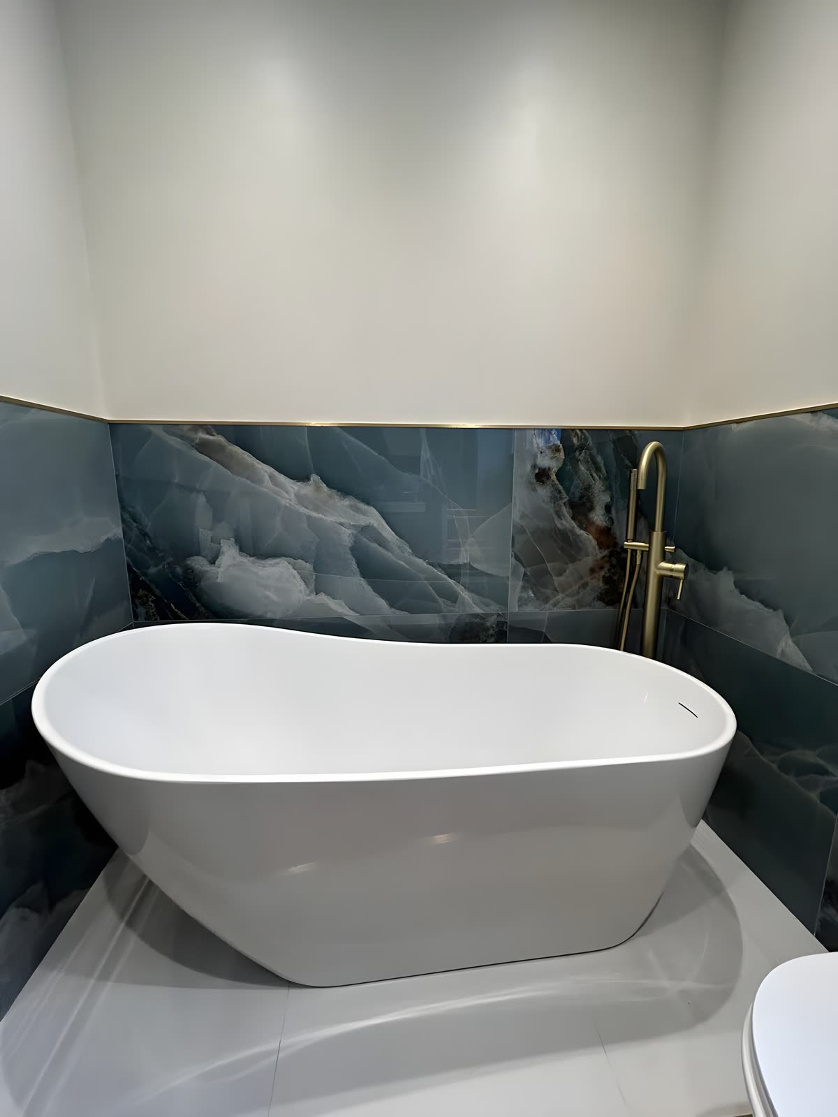 Freestanding slipper bath centred on the onyx feature wall