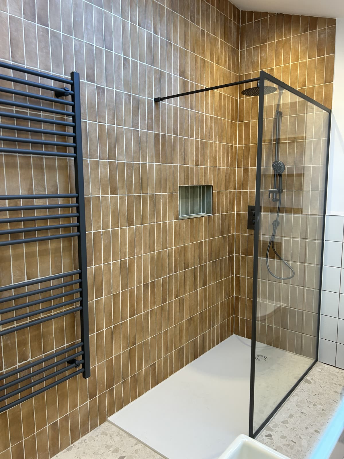 Black framed shower screen with a matching black ladder radiator