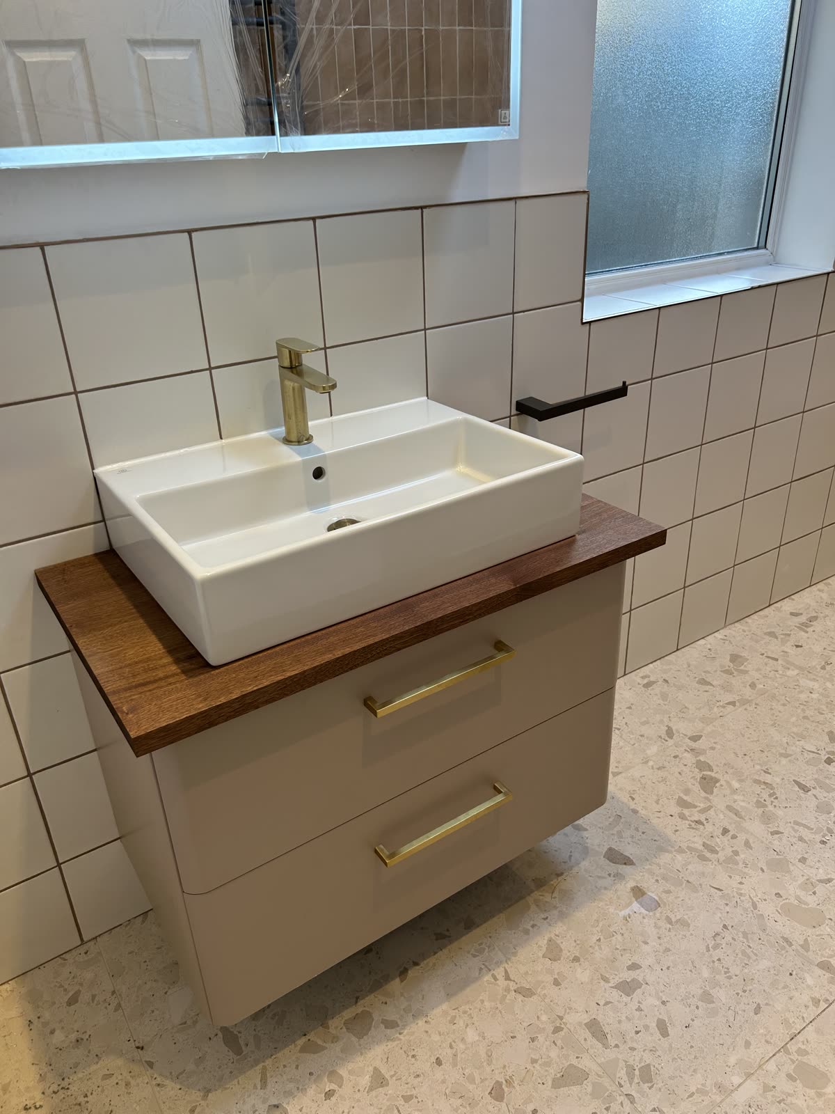 Countertop basin on a solid walnut top with a brass tap