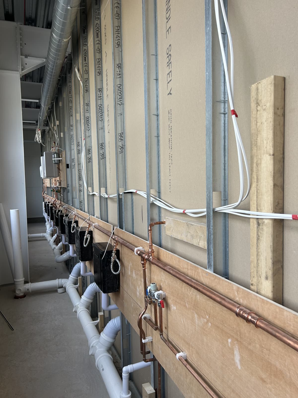 First-fix copper pipework, ductwork and steel stud partitions on site