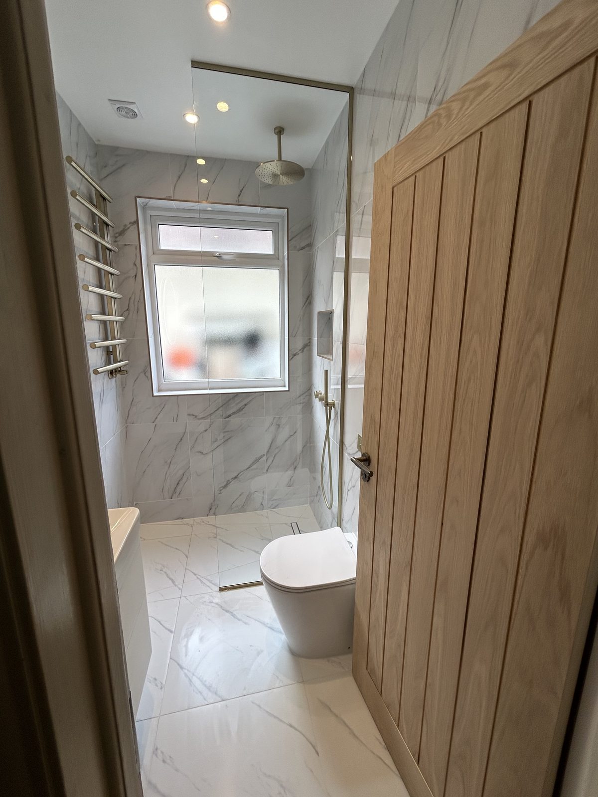 Wet-room shower area and WC seen from the oak door