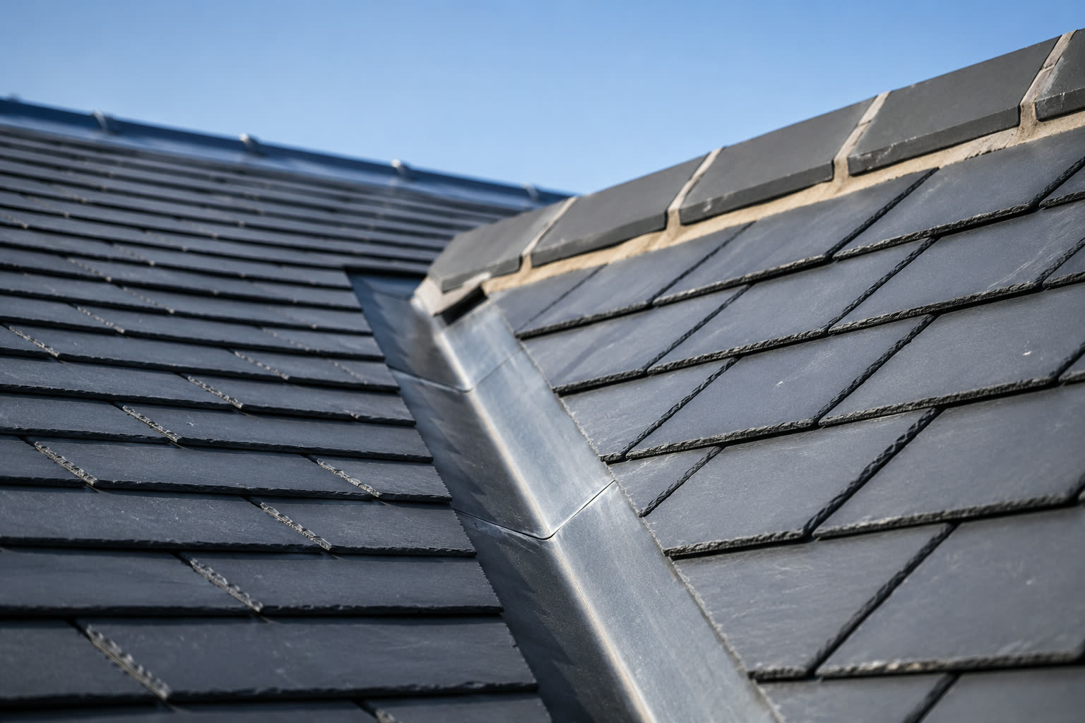 Slate roof and brick chimney seen from scaffold height in low sunlight